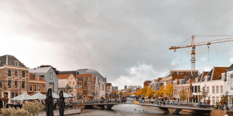 Stadsvy i Leiden, Nederländerna: flod, hus och en lyftkran