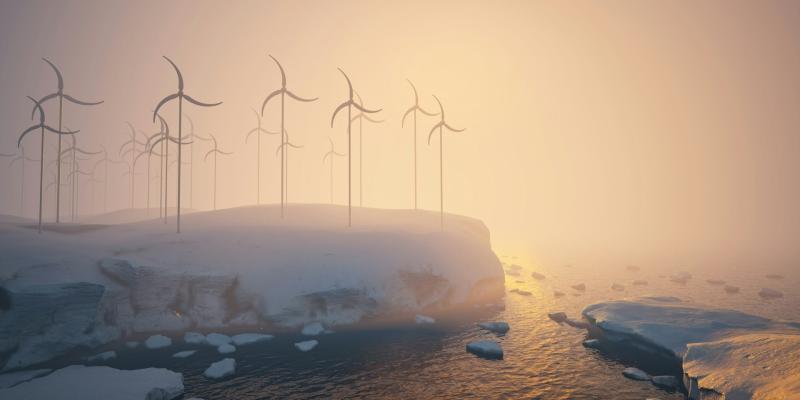 A group of windmills on a snowy hill next to a body of water 