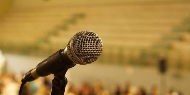 Närbild av mikrofon framför auditorium.