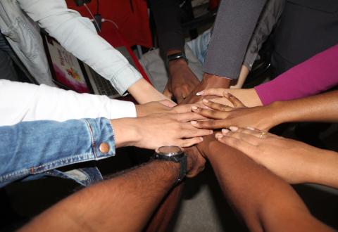 Ten hands in a circle as a sign of partnership and cooperation.